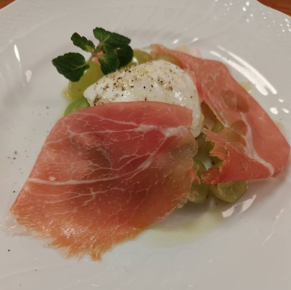 西那須野駅近くにある『ナスシオバル　ウニコ』の「モッツァレラチーズとシャインマスカット。生ハム添え」の写真