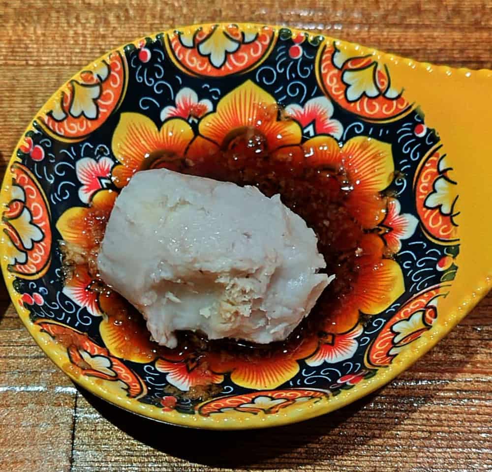 「里芋の極み」で、皮を剥いた里芋を生姜醬油に付けている様子