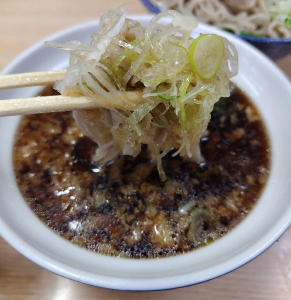 つけ汁にそばを浸して食べる様子