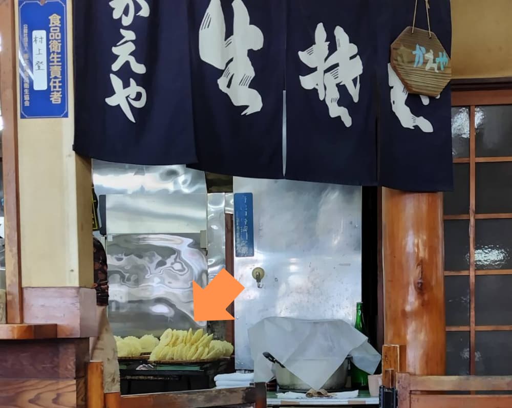 厨房に大量の天ぷらが並んでいる写真