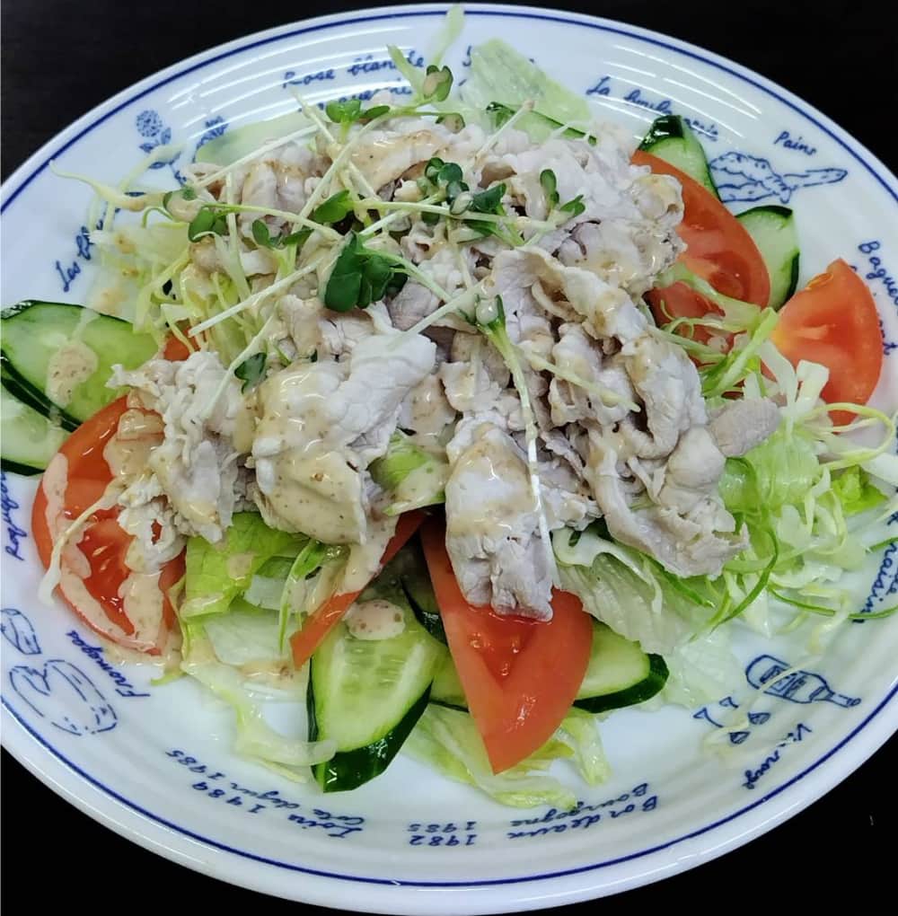 居酒屋「食べごろ」の「豚しゃぶのサラダ」にゴマダレを掛けた写真