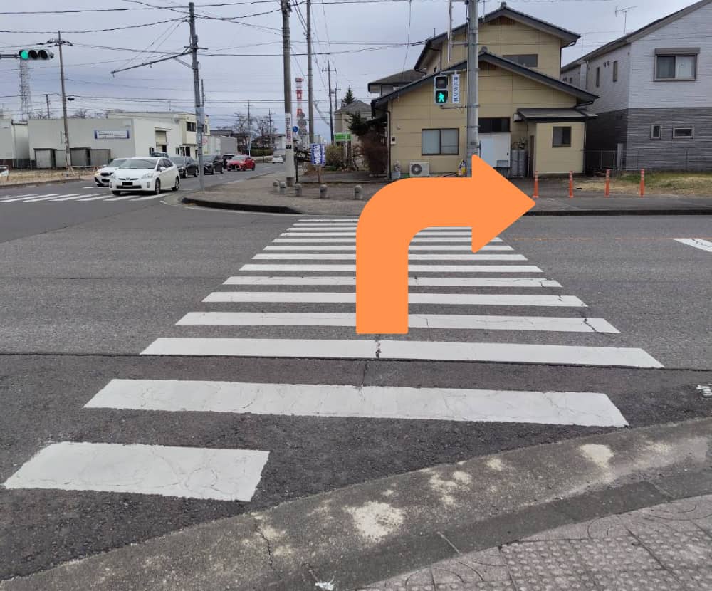 もみじ通りの横断歩道を渡って右折する写真