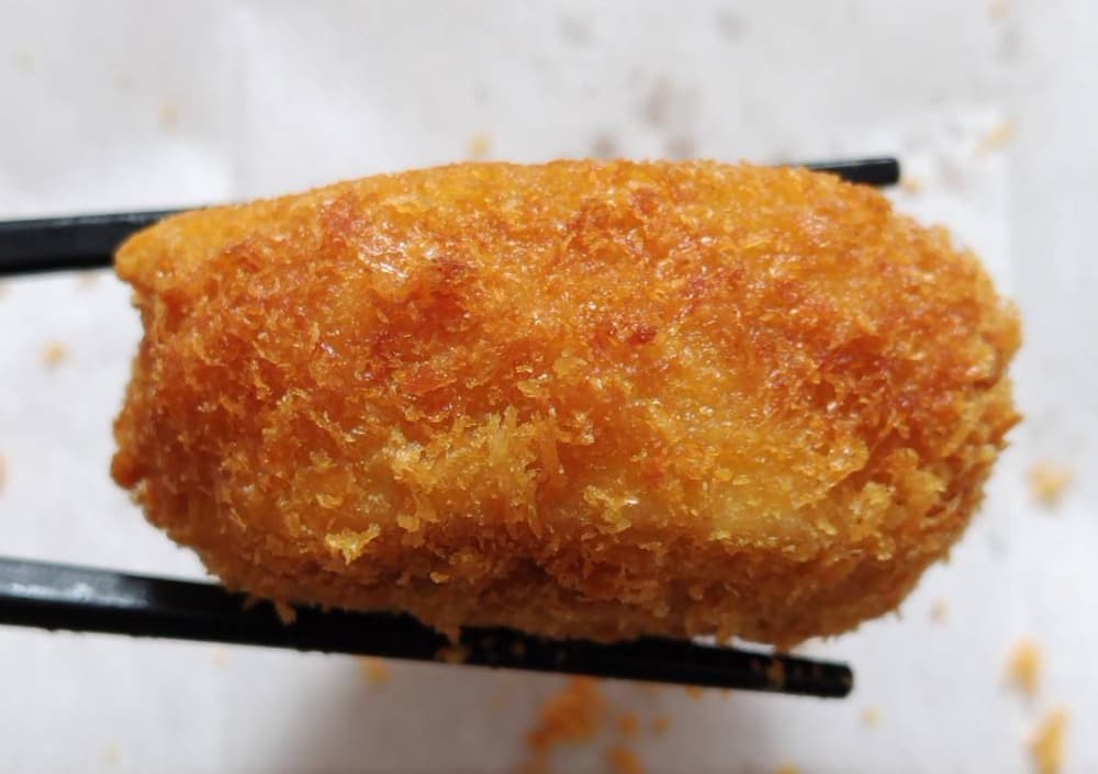 レンコン肉詰めフライを箸で持っている様子