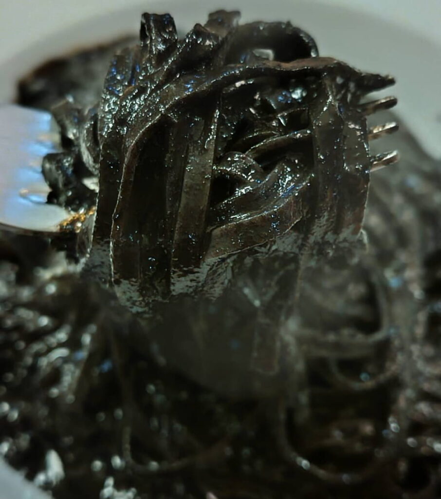 イカスミパスタをフォークで持ち上げている様子